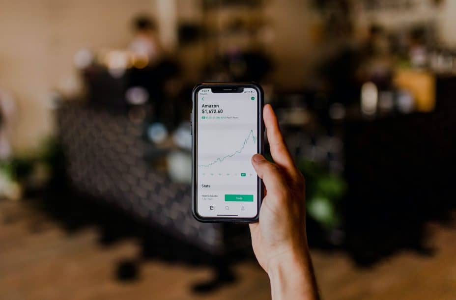 hand holding smartphone showing amazon stocks